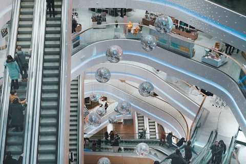 Shopping centre with escalators in the centre and people travelling up