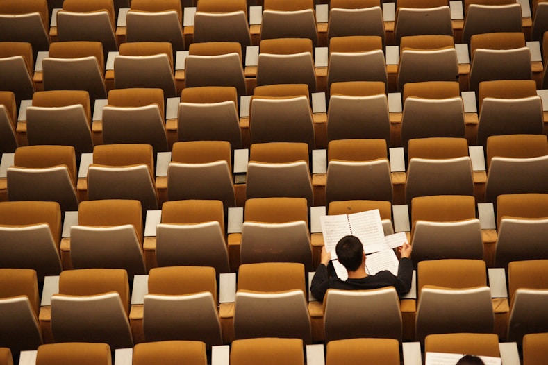 a man sat in an empty auditorium
