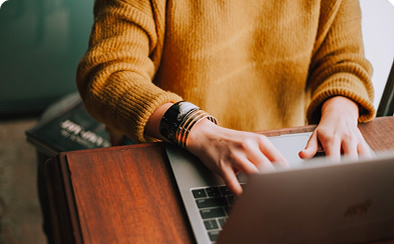 A Peter and clark employee sits at a desk on their laptop typing