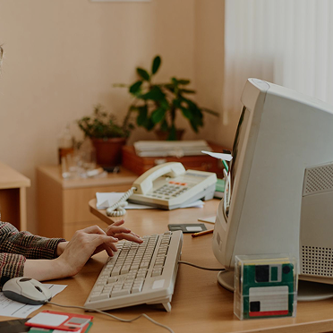 A Peter and Clark sits at a computer from the 1990s