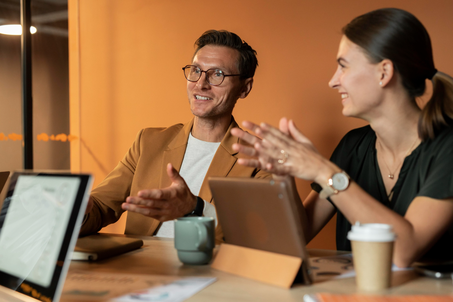 A content discussion in an office meeting room 2 people sit discussing content strategy