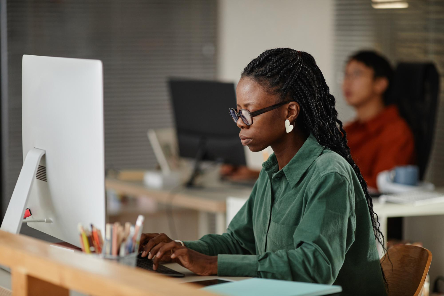 A proofreader sits at their desk intently reviewing copy