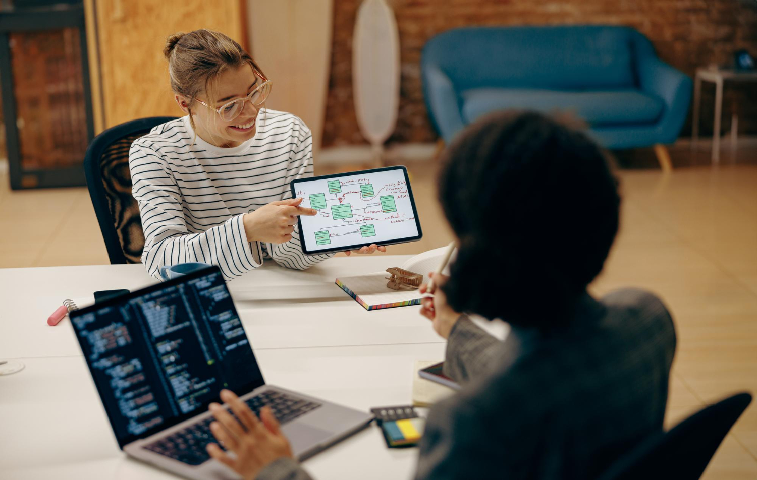 A content strategist is sat at the clients desk explaining a new ai focused content workflow
