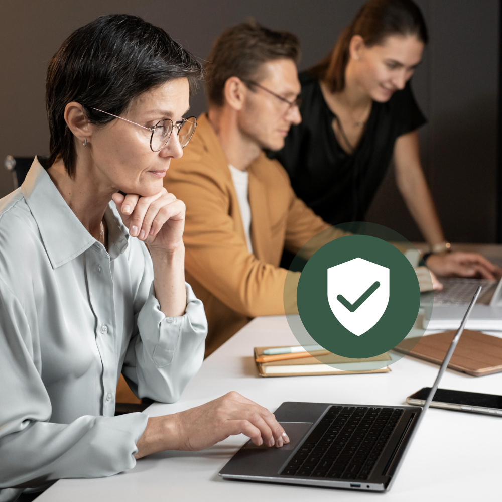 3 People working in an office space a peter and clark employee follows security protocols to keep work secure
