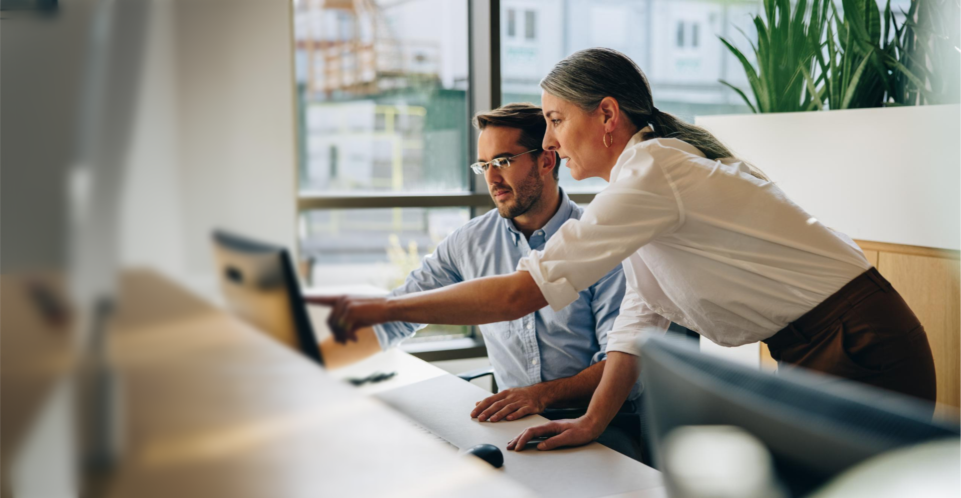 2 people at a desk working on a client project in a modern office