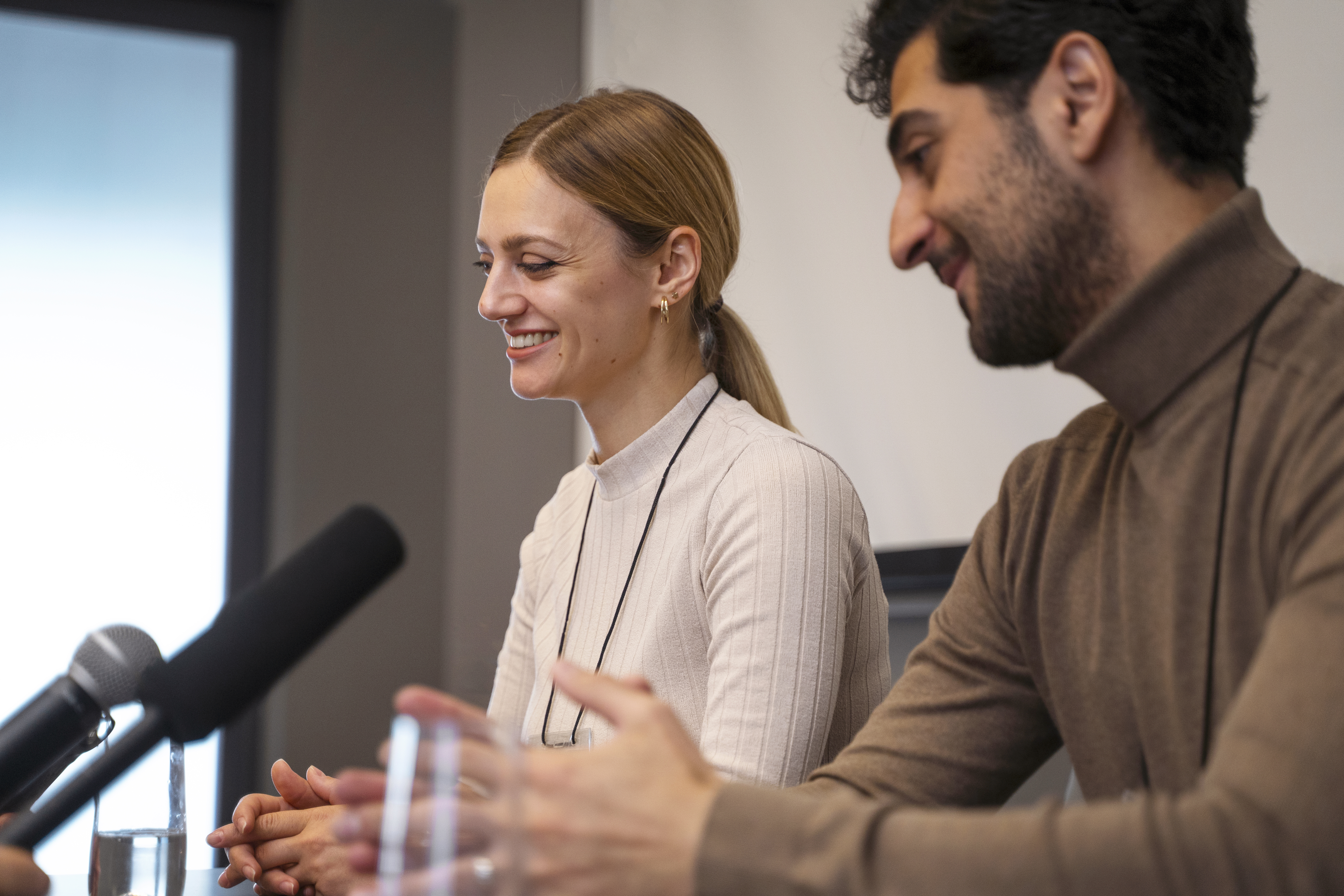 2 people at a press conference 1 interpreting and another speaking